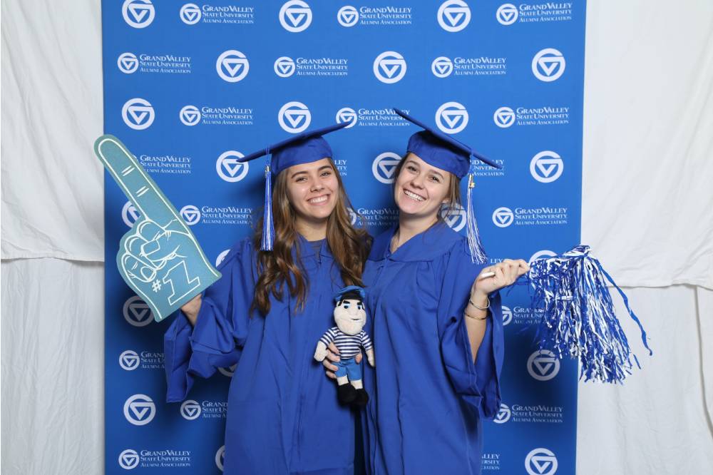 Two upcoming graduates pose with props at Gradfest